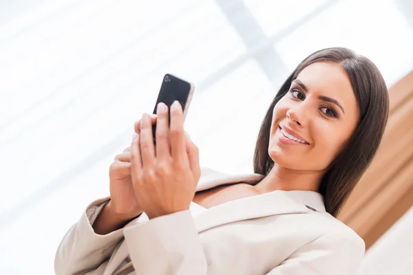 Деловая женщина держит мобильный телефон — стоковое фото