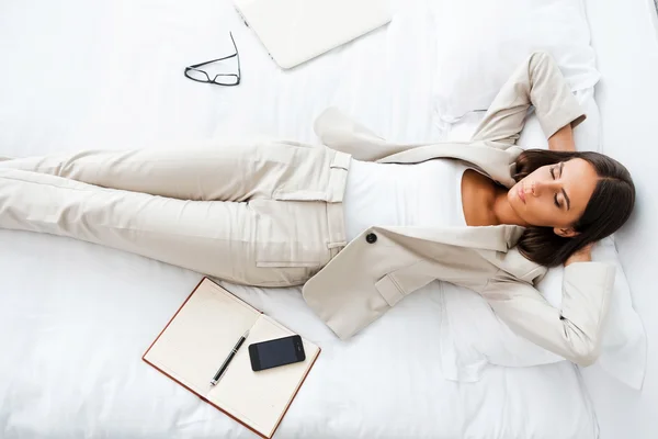 Mujer de negocios acostada en la cama en la habitación del hotel —  Fotos de Stock