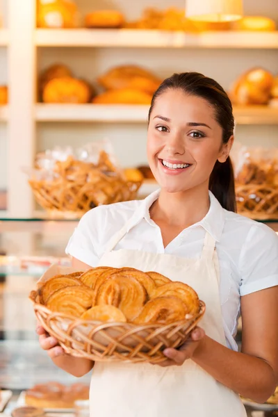 Woman in apron holding basket with baked goods — Stock Photo, Image