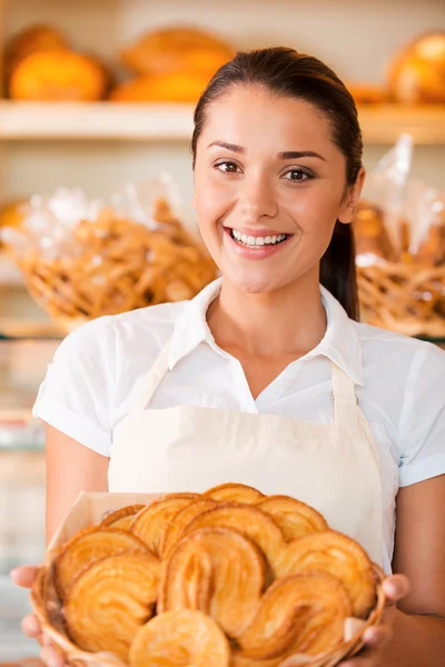 Woman in apron holding basket with baked goods — Stock Photo, Image