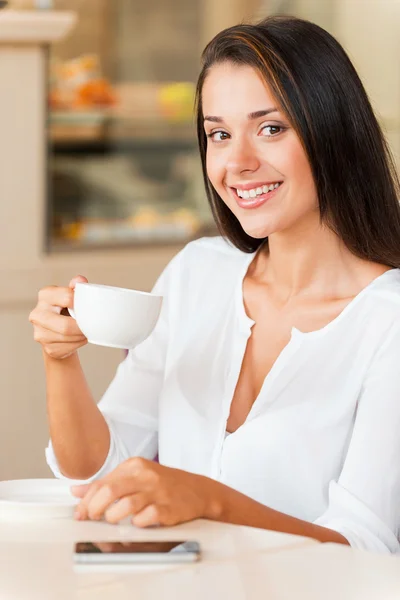 Woman drinking coffee and smiling — Stock Photo, Image