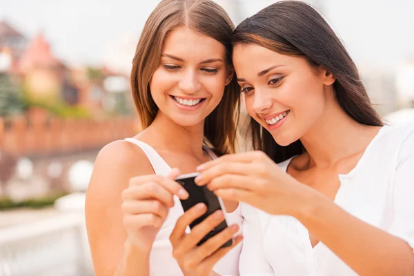 Mulheres olhando para o telefone móvel — Fotografia de Stock