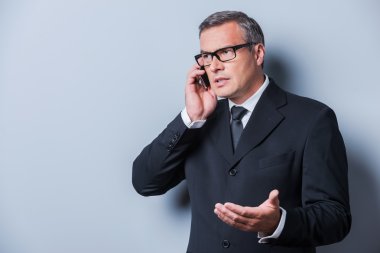 Mobil telefonda konuşurken resmi kıyafeti içinde olgun adam