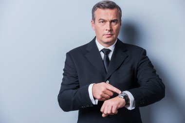 Olgun erkek saati gösteren resmi kıyafeti içinde