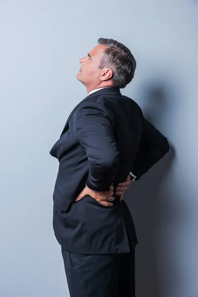 Mature man in formalwear with pain in back — Stock Photo, Image