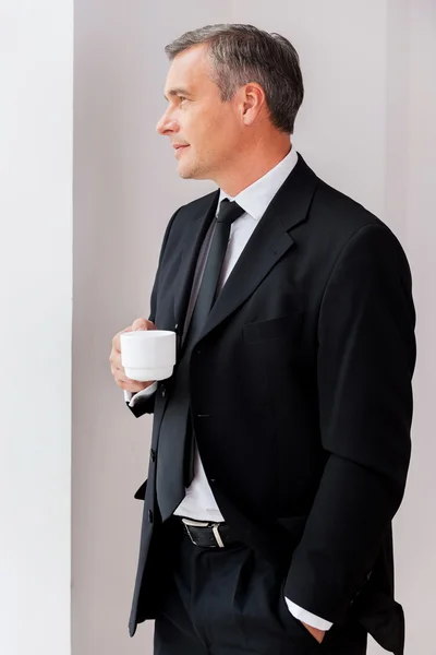 Zralý muž v úvazy držící šálek kávy — Stock fotografie