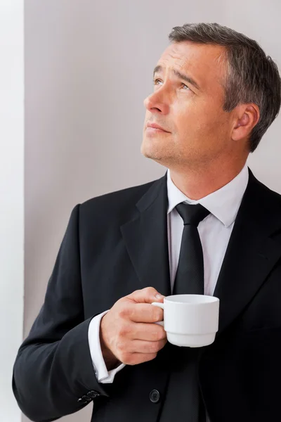 Зрелый мужчина в формальной одежде держит чашку кофе — стоковое фото