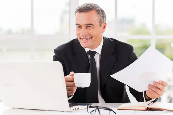 Homme mûr travaillant et buvant du café — Photo