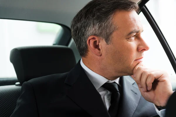 Businessman on the back seat of car — Stock Photo, Image