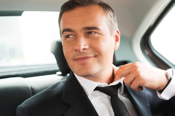 Businessman on the back seat of a car — Stock Photo, Image