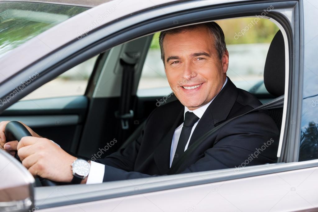 Mature man in formalwear driving car