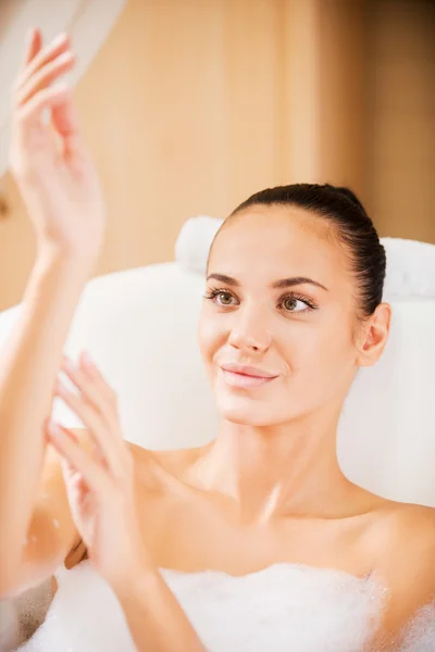 Frau berührt ihre Hand in Badewanne — Stockfoto