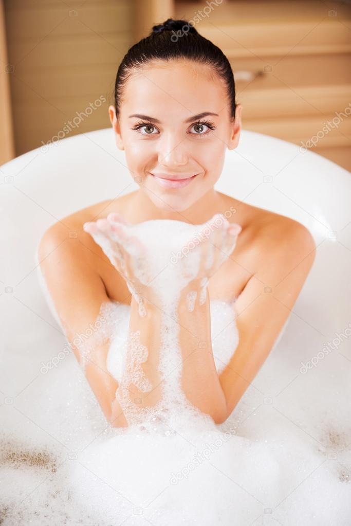 Woman holding soap sud in her hands