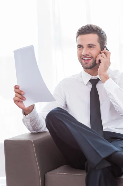 Businessman talking on phone and holding document — Stock Photo, Image