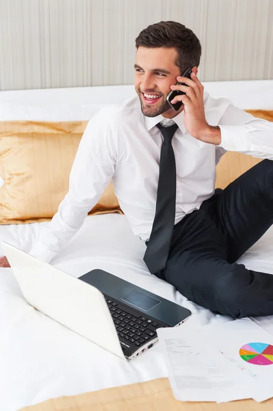 Homem de camisa e gravata trabalhando no quarto do otel laptop — Fotografia de Stock