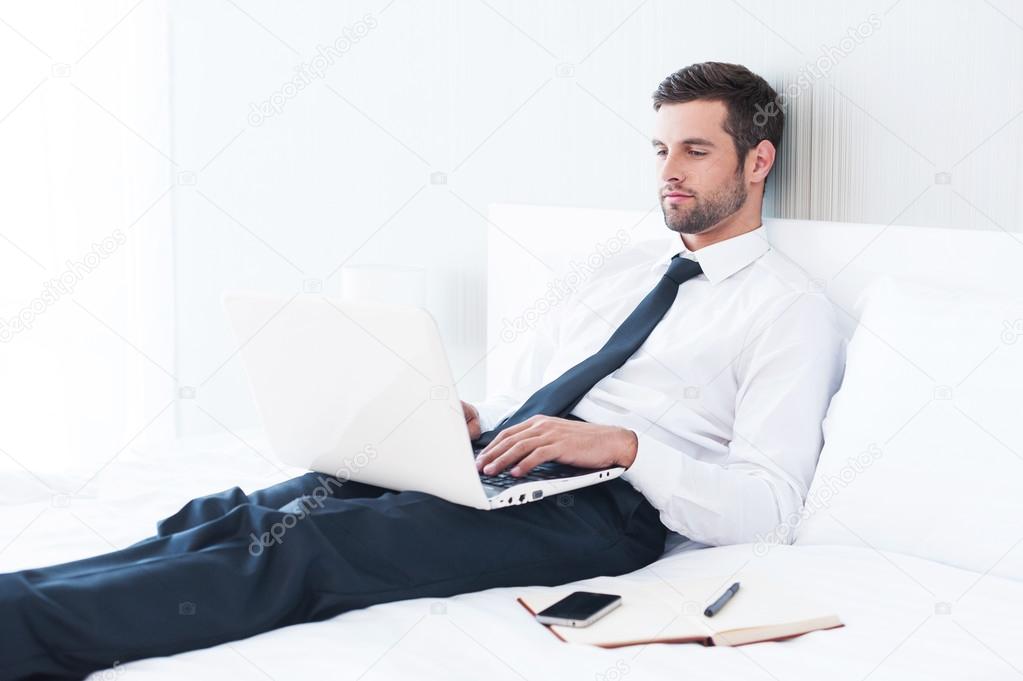 Man in shirt and tie working on laptop