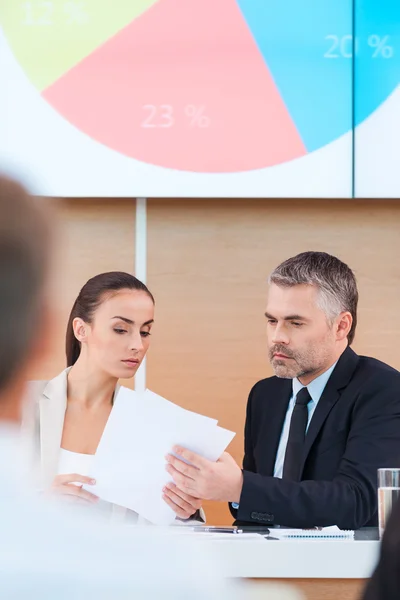 Man and woman in formalwear looking at paper — Stockfoto