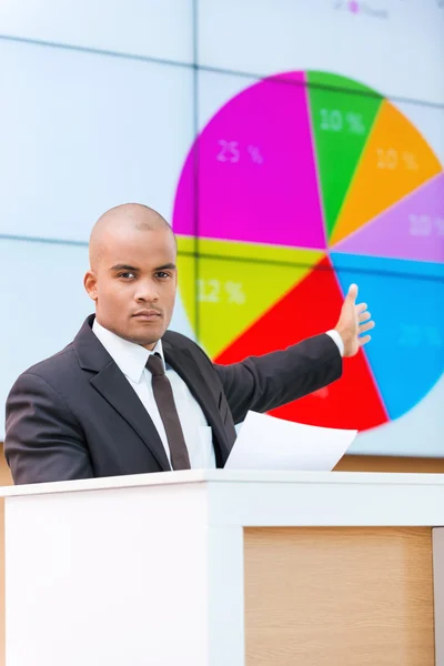 Hombre africano en ropa formal de pie en la tribuna — Foto de Stock