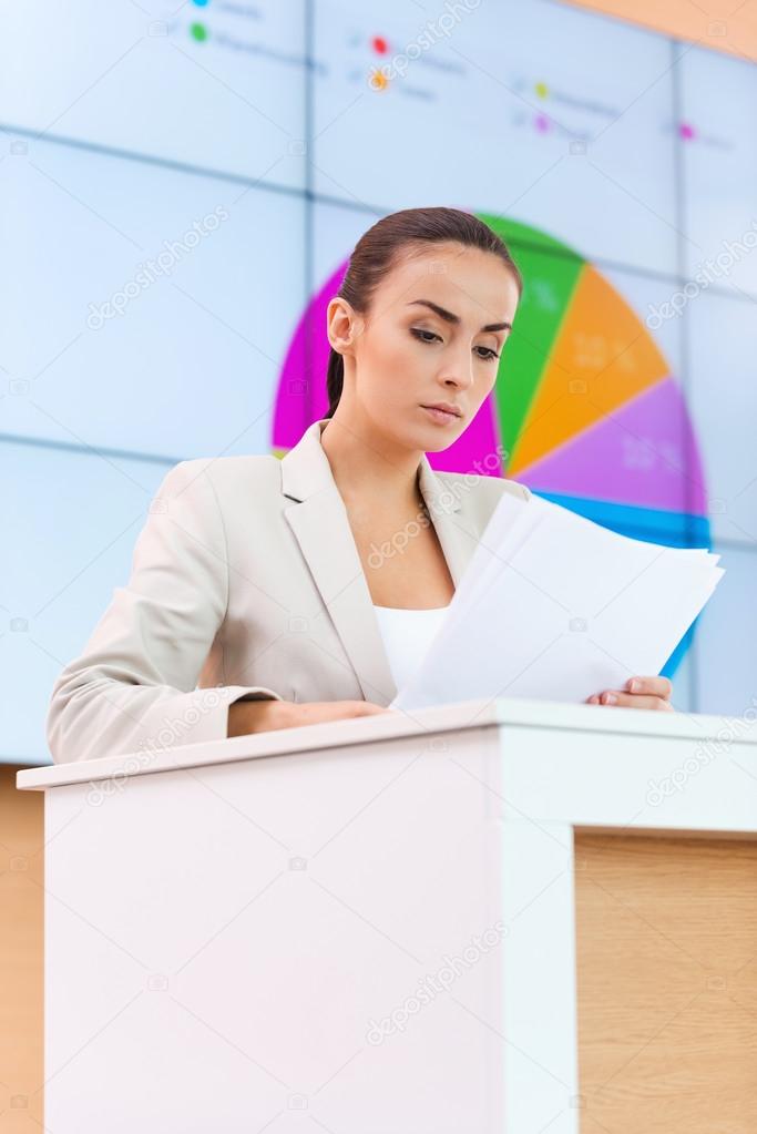 Woman in formalwear standing at the tribune