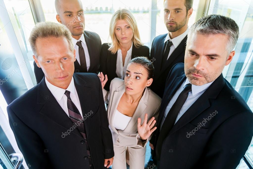 Woman in formalwear feeling trapped by the crowd in elevator