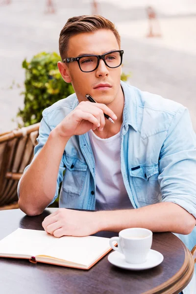 Hombre tocándose la barbilla con pluma — Foto de Stock