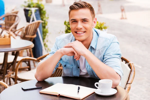 Homme assis dans un café sur le trottoir — Photo