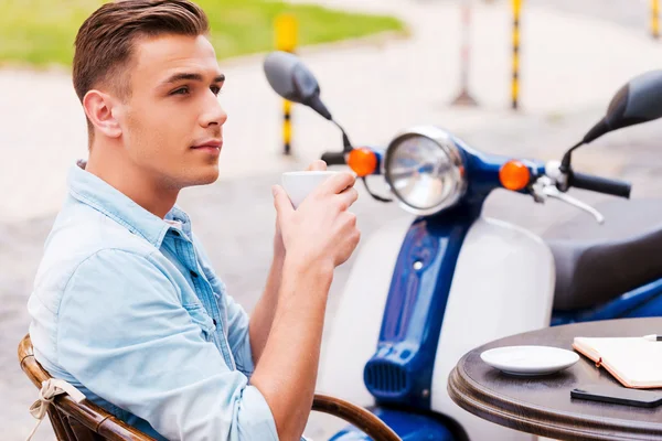 Mann trinkt Kaffee, während er im Straßencafé sitzt — Stockfoto