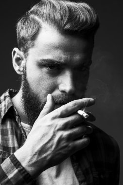 Bearded man smoking. clipart