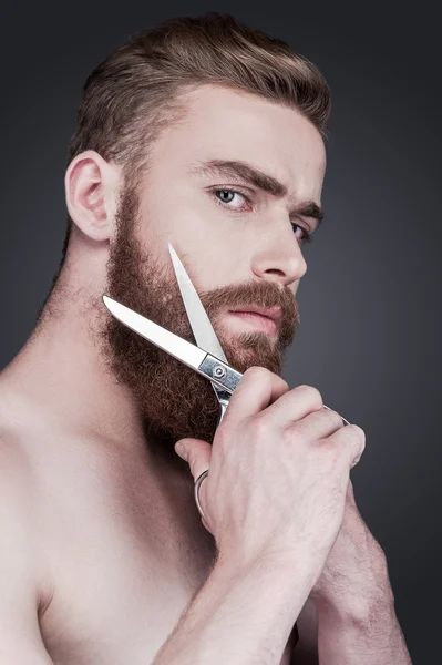 Без сорочки чоловік ріже свою бороду ножицями — стокове фото