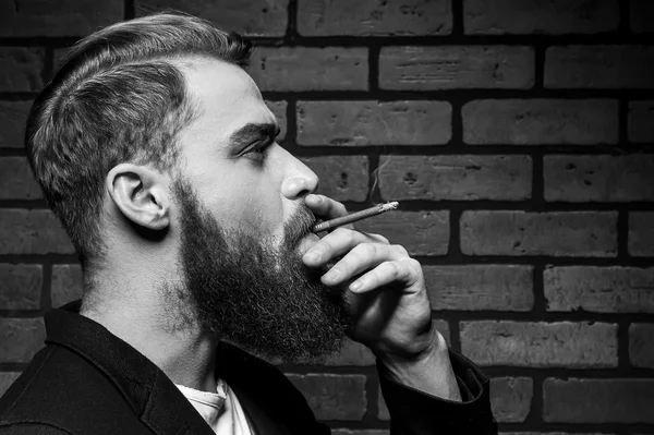 Giovane uomo barbuto fumare — Foto Stock