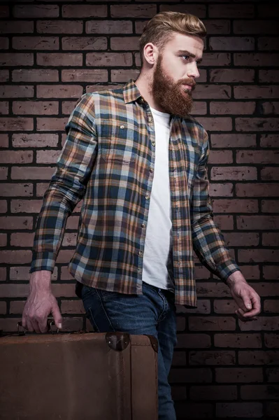 Бородатый мужчина с чемоданом — стоковое фото