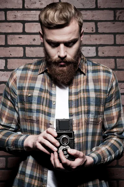 Бородатый мужчина держит старомодную камеру — стоковое фото