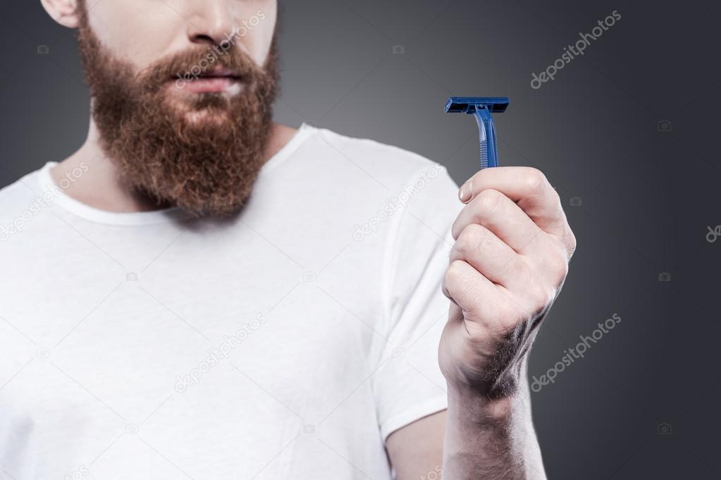 Bearded man holding razor