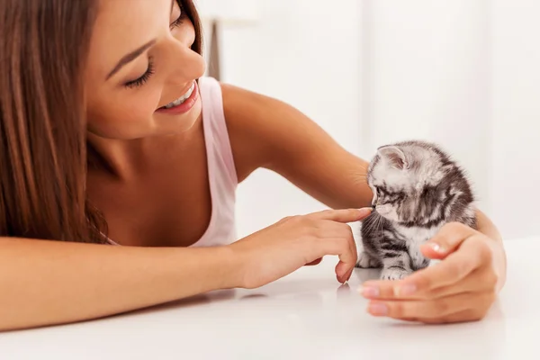 Gatinho sentado na mesa com a jovem — Fotografia de Stock