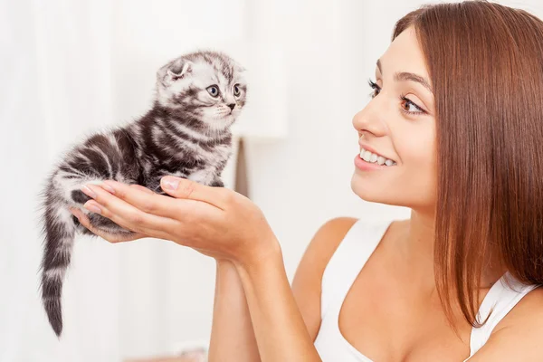 Mujer sosteniendo pequeño gatito en manos — Foto de Stock