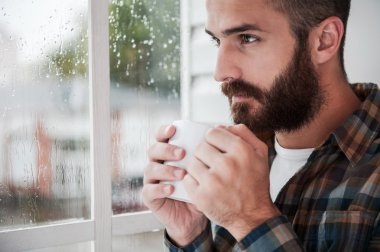 sakallı adam fincan sıcak bir içecek ile holding