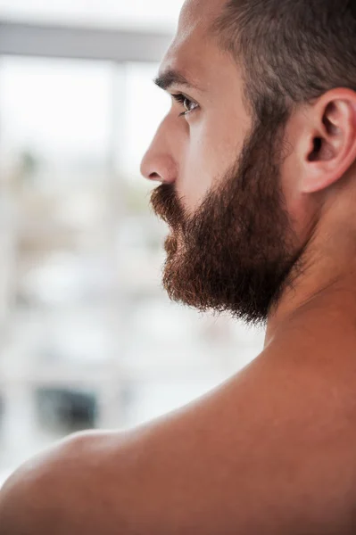 Thoughtful young bearded and shirtless man — Stock Photo, Image