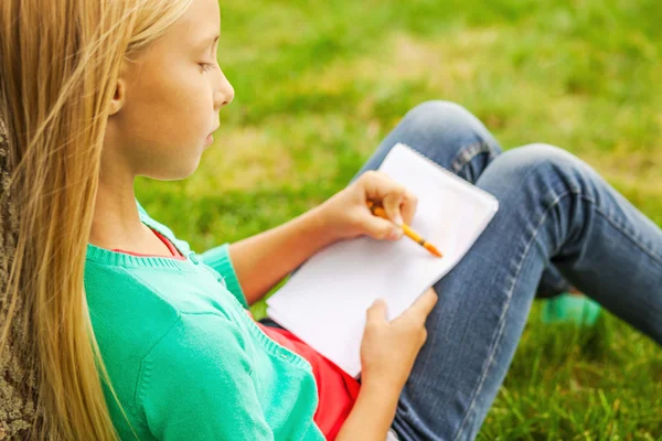 Little girl drawing something at her note pad — Stock Photo, Image