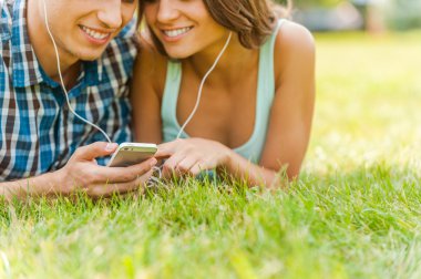 Çift çim üzerinde yalan ve müzik telefon seçimi