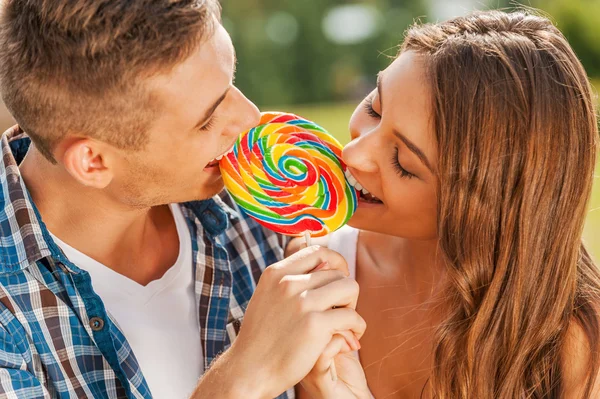 Couple tasting multi colored lollipop — Stock Photo, Image