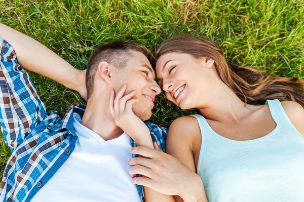 Jong paar liggend op het gras — Stockfoto