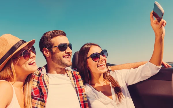 Gente en convertible y haciendo selfie — Foto de Stock