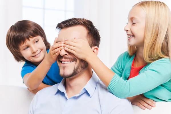 Дети закрывают глаза весёлого отца — стоковое фото
