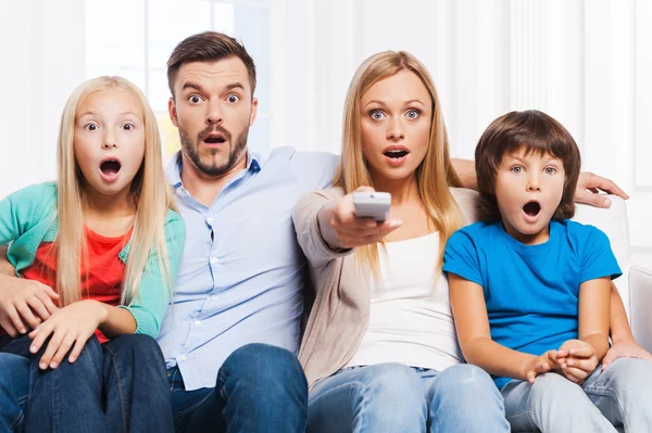 Família surpresa assistindo TV em casa — Fotografia de Stock