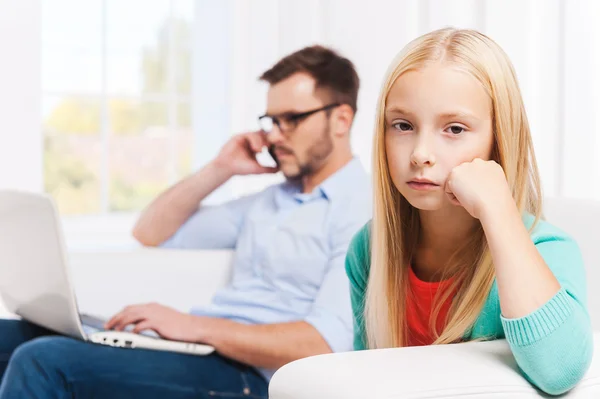 Man working on laptop with his upset daughter — Stock Photo, Image