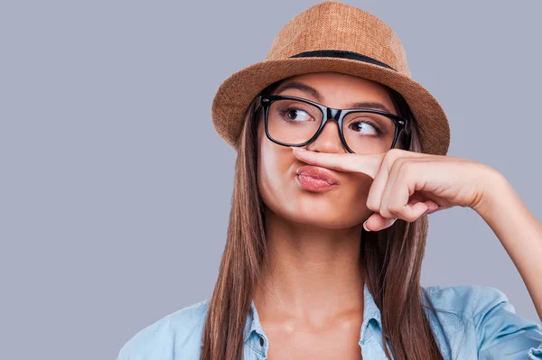 Woman holding a finger up to her nose — Stock Photo, Image