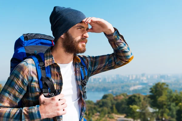 Homem carregando mochila e olhando para longe — Fotografia de Stock