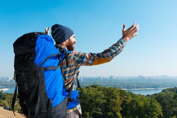 Man carrying backpack with raising arms — Stock Photo, Image