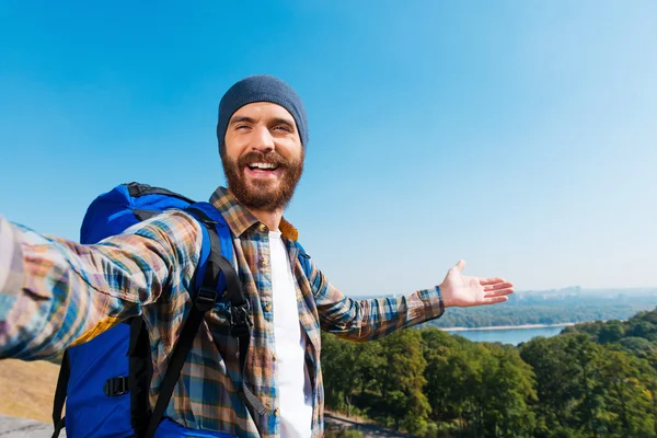 Man carrying backpack and taking a picture — Stock Photo, Image