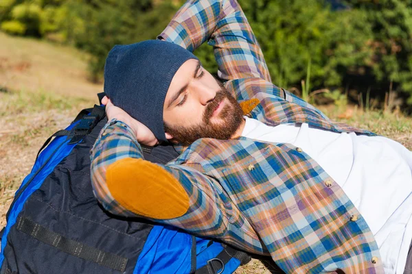 Ung man som ligger på ryggsäcken — Stockfoto